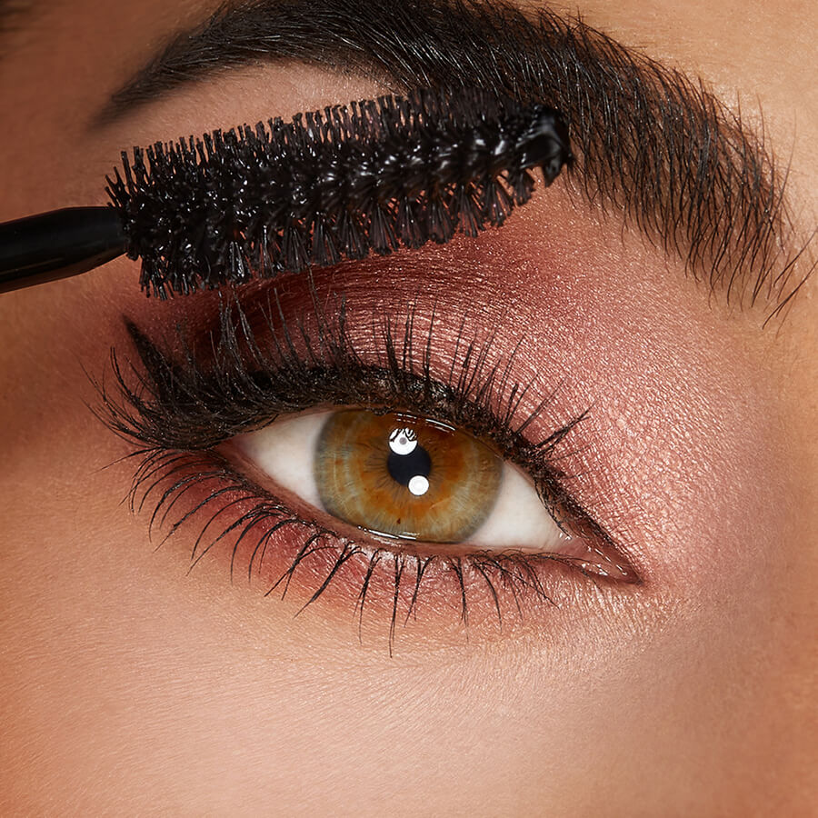 "Close-up of mascara being applied to eyelashes, showcasing the volume and definition."